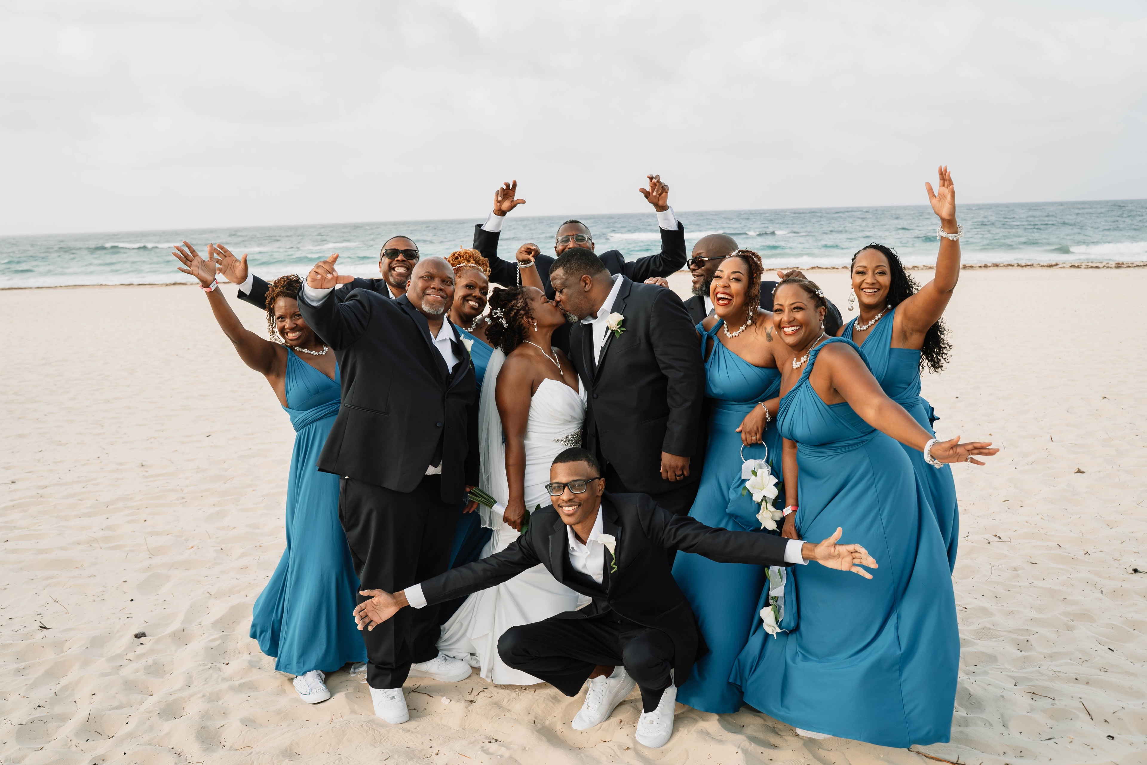 A joyful beach wedding party celebrating on the sand